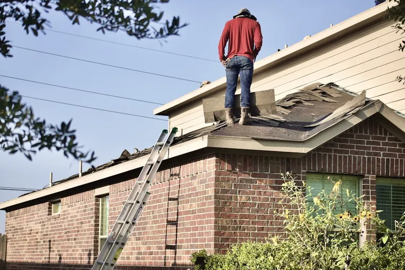 Professional roofer working on a residential roof in Romulus